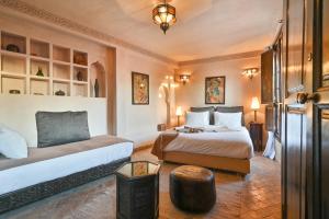 una camera d'albergo con due letti e un tavolo di Riad Aya a Marrakech