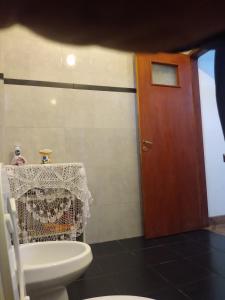 a bathroom with a toilet and a wooden door at Los Hermanos Fernández in Reyes