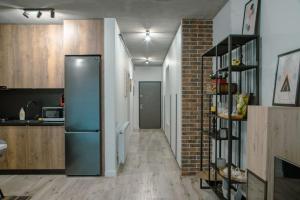 a kitchen with a refrigerator and a brick wall at Cozy Apartment in Floreşti