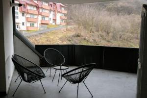 two chairs and a table on a balcony with a view at Cozy Apartment in Floreşti
