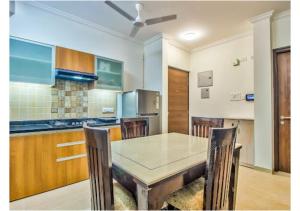 een keuken met een tafel en stoelen in een kamer bij Telferk Acron Seawinds Apartment- Baga in Calangute