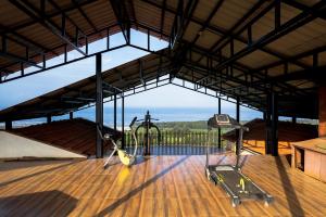 a gym with a view of the ocean from inside a building at Sea Nest Villa, 3BHK Panoramic Sea View , Ganpatipule in Ratnagiri