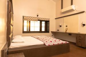 a bedroom with a bed and a sink and a window at Sea Nest Villa, 3BHK Panoramic Sea View , Ganpatipule in Ratnagiri