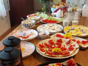 a wooden table with plates of food on it at Złota Wójtówka in Wydminy