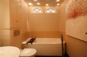 ein Badezimmer mit einer weißen Badewanne und einem WC in der Unterkunft Ruarklef in Kampen + 25 Fotos