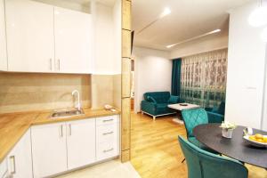a kitchen and living room with a table and chairs at Downtown apartment in Banja Luka
