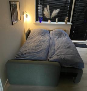 ein Bett mit zwei Kissen auf einem Zimmer in der Unterkunft AgerBro in Broager