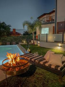 a fire pit in a yard next to a pool at Good Life Resort in La Falda