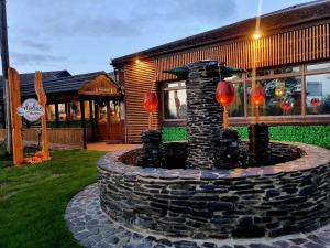 a stone fountain in front of a building at Travel Plaza Hotel in Desborough
