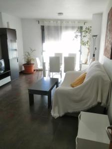 a bedroom with a bed and a table and chairs at Apartamento Gloria Patricia in Alcantarilla