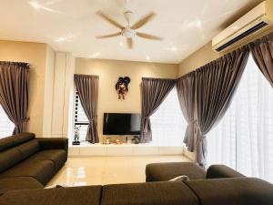 a living room with a couch and a ceiling fan at 《Untitled HomeStay》Sitiawan in Sitiawan