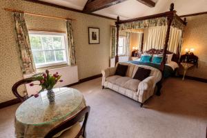 a bedroom with a bed and a couch and a table at Hodgkinsons Hotel Matlock Bath in Matlock