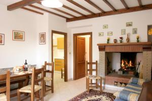 a living room with a table and a fireplace at Il Giardino degli Ulivi Castiglione del Lago in Pozzuolo