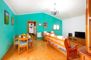 comedor con paredes azules, mesa y sillas en Finca Tropical en Ingenio