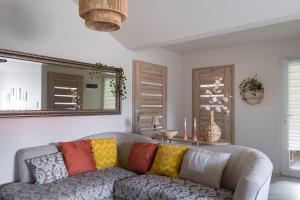 Agroturystyka z Alpakami Mazury في مارونجوفو: غرفة معيشة مع أريكة مع وسائد ملونة