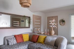 a living room with a couch with colorful pillows at Agroturystyka z Alpakami Mazury in Mrągowo