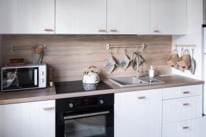 a kitchen with a sink and a microwave at Agroalpaka Mazury in Mrągowo