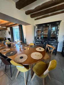 a dining room with a large wooden table and chairs at Le Val de Nodicia in Montlivault