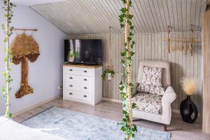 ein Wohnzimmer mit einem Stuhl und einem TV in der Unterkunft Agroturystyka z Alpakami Mazury in Mrągowo