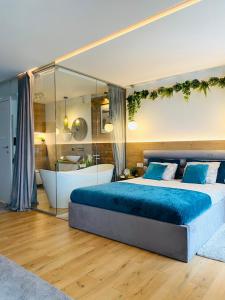um quarto com uma cama grande e uma banheira em Apartament MoLoo III em Ostróda