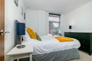 Un dormitorio con una cama grande y una mesa con una lámpara. en *20% off Monthly* St Albans City Centre Apartment en Saint Albans