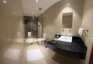 La salle de bains est pourvue d'un lavabo, d'une douche et de toilettes. dans l'établissement Muscat Express Hotel, à Mascate