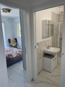a white bathroom with a sink and a bed at Isole in Baveno