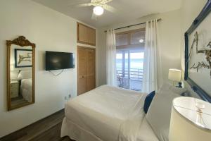 um quarto com uma cama, um espelho e uma televisão em Anchor's Aweigh em St. George Island