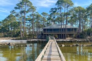 a wooden bridge leading to a house on the water at Anchor's Aweigh in St. George Island