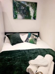 ein Schlafzimmer mit einem Bett mit einer grünen Bettdecke in der Unterkunft (S7) Great Studio Next To A Tube Station! in Harrow on the Hill