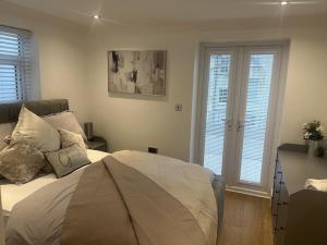 a bedroom with a bed and two windows with shutters at Gorgeous 2 floor 3 bed Apartment in St. Leonards