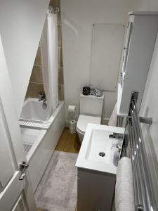 a white bathroom with a toilet and a sink at Gorgeous 2 floor 3 bed Apartment in St. Leonards