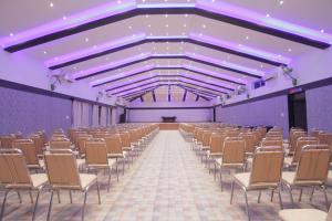 a large room with rows of chairs and purple walls at Reva Resorts and Holiday Homes in Chittoor