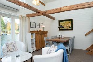a dining room with a table and white chairs at Seaside Cottage House nr 1, Saltvik Hudiksvall in Hudiksvall