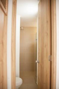 a bathroom with a toilet and a glass shower at Duplex Familiar Apartment Nature in Guatapé