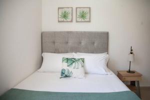 a bedroom with a white bed with two pictures on the wall at Duplex Familiar Apartment Nature in Guatapé