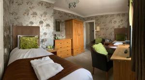 1 dormitorio con cama, escritorio y silla en Ramsey House - Luxury Licensed B&B - Parking and Guest Lounge, en St. Davids