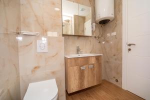 a bathroom with a toilet and a sink and a mirror at Hotel Pharos in Bar