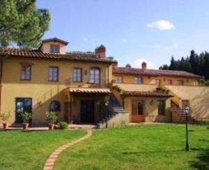 uma casa grande com um relvado verde em frente em Appartamento Lavanda em San Miniato