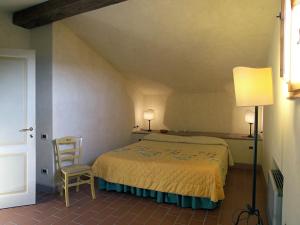 a bedroom with a bed and a chair in a room at Appartamento Geranio in San Miniato