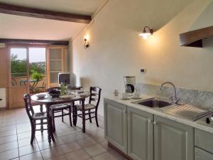 uma cozinha com um lavatório e uma mesa com cadeiras em Appartamento Begonia em San Miniato