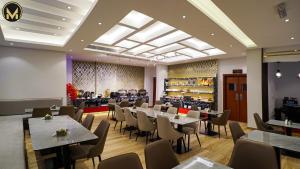 una sala da pranzo con tavoli e sedie in un ristorante di Muscat Express Hotel a Mascate