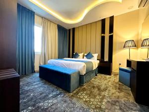 a hotel room with a bed and a blue couch at فندق فصل الصيف امان - المنسك in Abha