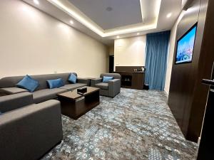ein Wohnzimmer mit einem Sofa und einem Flachbild-TV in der Unterkunft فندق فصل الصيف امان - المنسك in Abha