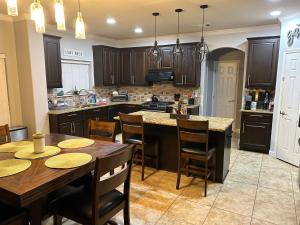 a kitchen with wooden cabinets and a table with chairs at The Nog Inn in Pflugerville