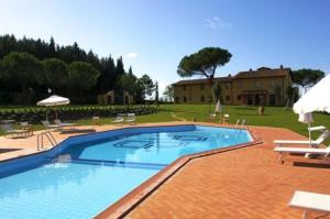a large swimming pool in a yard with a house at Appartamento Isabella in San Miniato