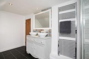a bathroom with two sinks and a mirror at Central 4 Bedroom House in Derby