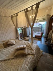 a bedroom with a large bed with a canopy at La maisonnette de Cancan in Mont-près-Chambord