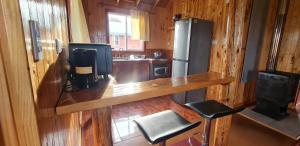 eine Küche mit einer Theke und einem Kühlschrank in der Unterkunft Cabañas Susurros del Bosque in Ancud