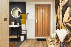 a bathroom with a sink and a wooden door at Le chalet des bois in Lalaye